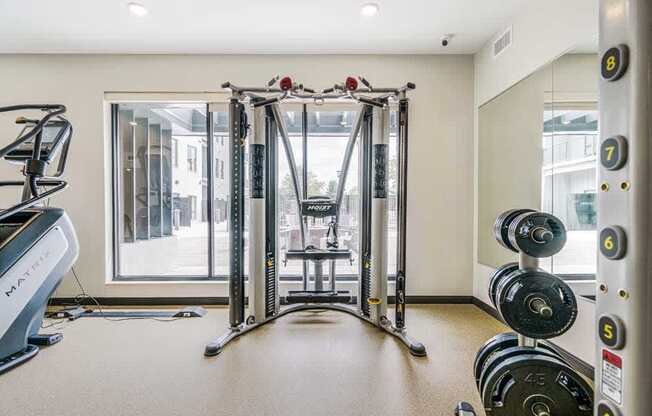 a 24-hour fitness center with a Smith machine and racks of weights
