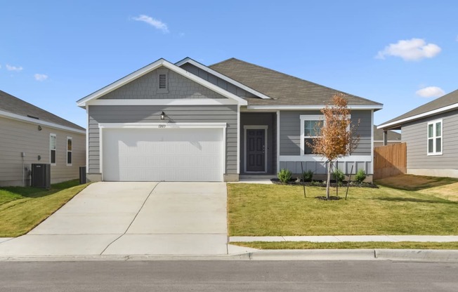 a home with a gray siding and a white garage door at Beacon at Presidential Heights, Manor, TX
