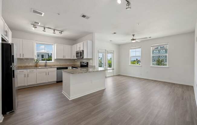 a kitchen and living room with hardwood floors and white walls