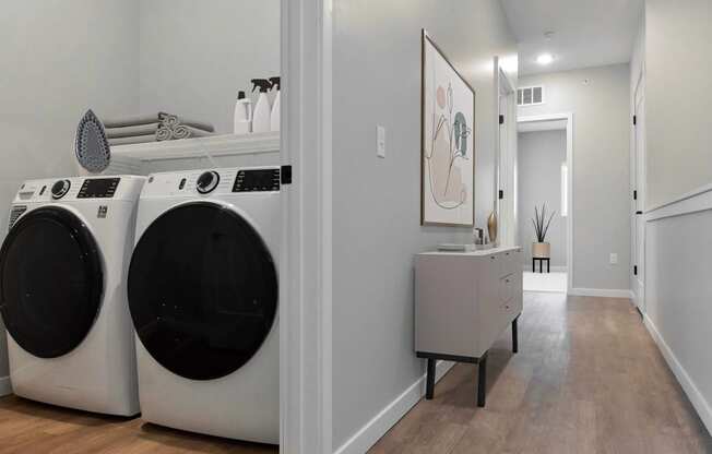 a washer and dryer in a laundry room with a sink and a mirror