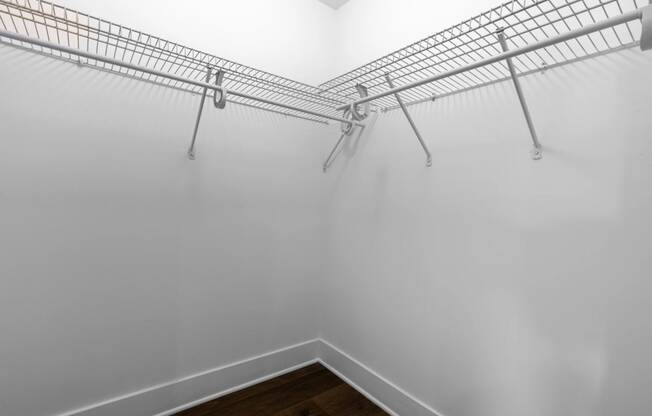 the closet in a bedroom with white walls and metal shelves