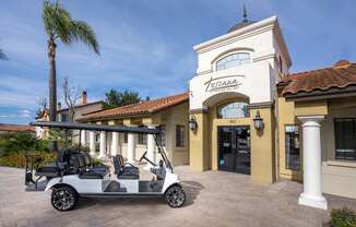 A white golf cart is parked in front of a building with a sign that reads "Teresa.".