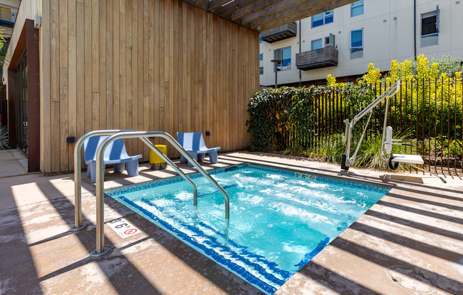 A small pool with a blue tiled edge and a metal ladder.