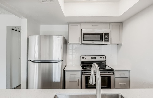 A modern kitchen with stainless steel appliances and white cabinets.