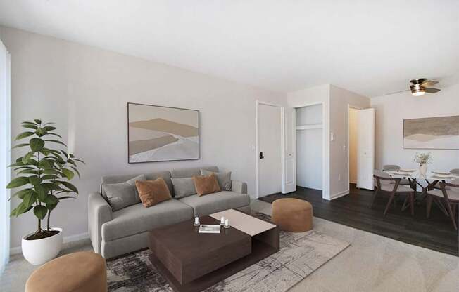 A living room with a grey couch, a brown coffee table, and a large painting on the wall.