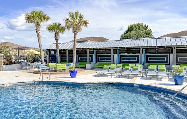 A pool with a metal roof and a few chairs and plants at Canebrake Apartment Homes in Shreveport, LA