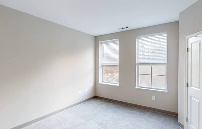 A room with two windows and a door.