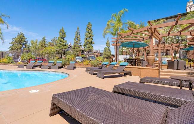 A pool area with sun loungers and a shaded seating area.