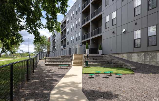 an apartment building with stairs and grass in front of it