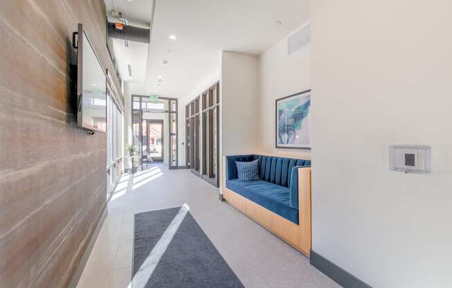 a long corridor with a blue couch on the left and a tv on the right at Marina Square, Washington, 98337