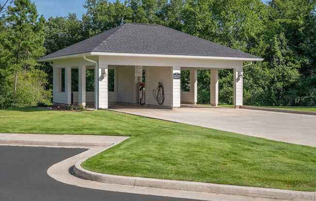 A white house with a black roof and a bicycle hanging on the wall.