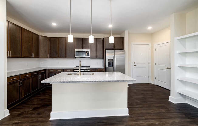 A kitchen with a white island and dark wood cabinets.