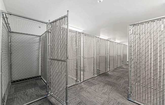 A room with a grey carpet and metal grills on the walls.