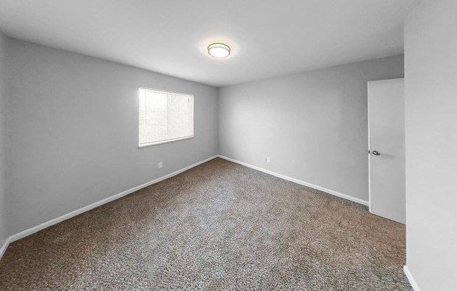 an empty room with carpet and a window