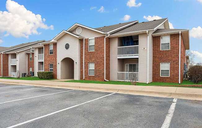 Apartment building with a parking lot in front.