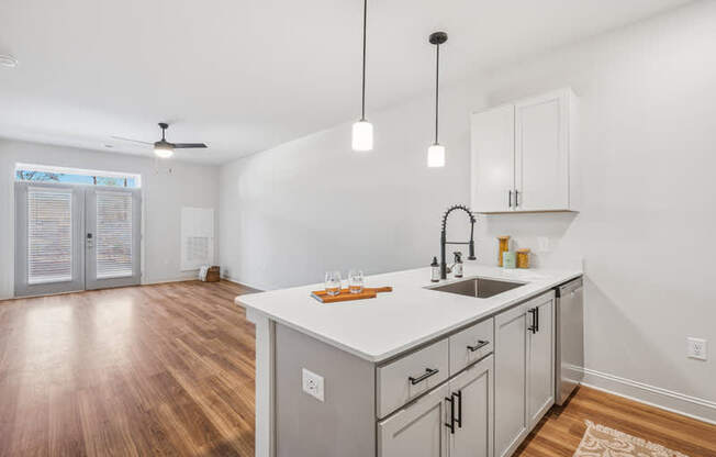 A kitchen with a white countertop and wooden floors.