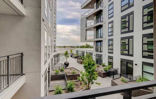 A balcony with a view of a building and a tree.