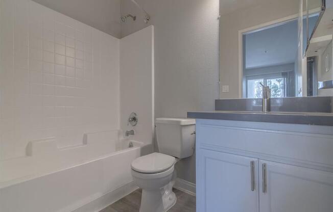 a bathroom with a toilet and a tub and a sink at Warner Center Townhomes, Canoga Park