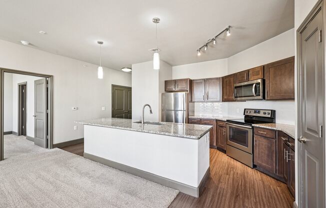 A modern kitchen with a white island and wooden cabinets.