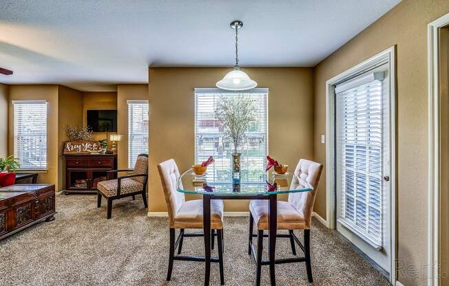 a dining room with a glass table and chairs and a large window