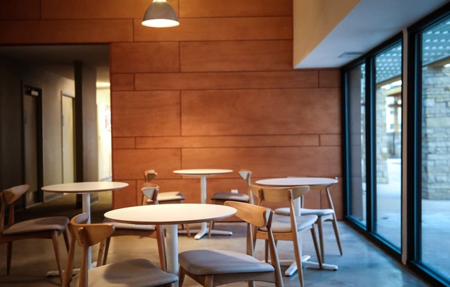 a dining room with tables and chairs in front of a wood wall