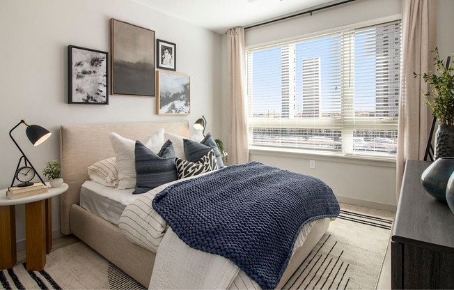 a bedroom with a bed and a large window