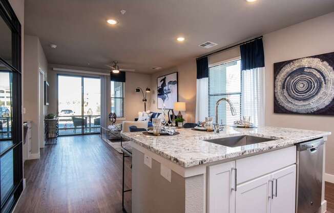 A modern kitchen with a marble countertop and stainless steel appliances.