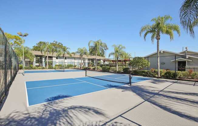 A tennis court with a net and a building in the background.