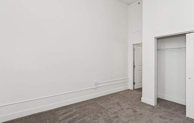 A room with a grey carpet and white walls.