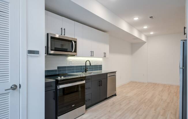 a kitchen with black and white cabinets and a microwave