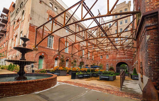 A courtyard with a fountain and a brick building.