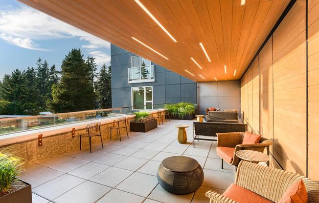 Relax beneath warm wood accents on Modera Shoreline’s terrace, offering inviting seating and tranquil treetop views.