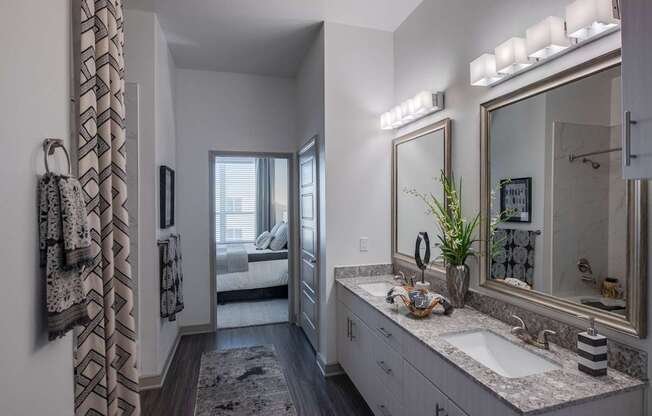 A bathroom with a large mirror and a sink.