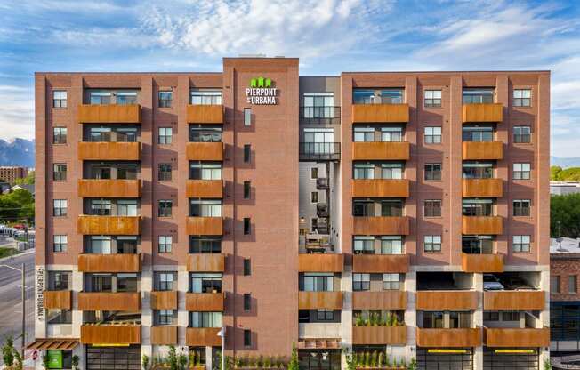 a large apartment building with a green logo on the side of it