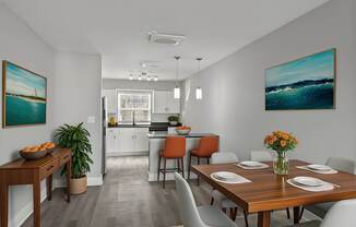 A dining room with a wooden table set for four at Mandarin Bay Apartments.