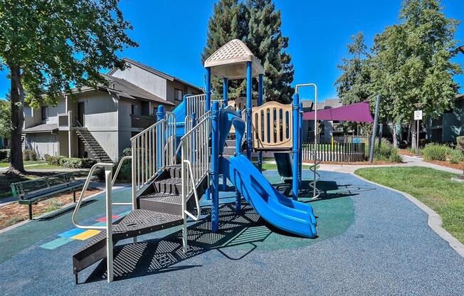 2-BR Apartments In Hayward, CA - The Dutton - Community Playground Surrounded By Trees And Grass