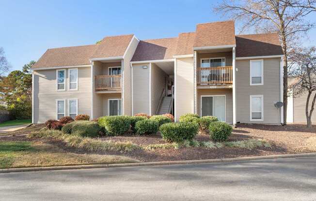 A two-story apartment building with a balcony on the second floor.