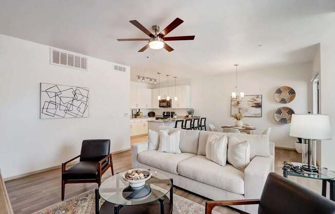 A living room with a white couch and a black chair.