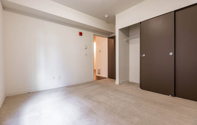 A room with a carpeted floor and a doorway leading to another room.