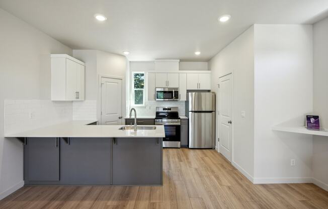a kitchen with white cabinets and stainless steel appliances
