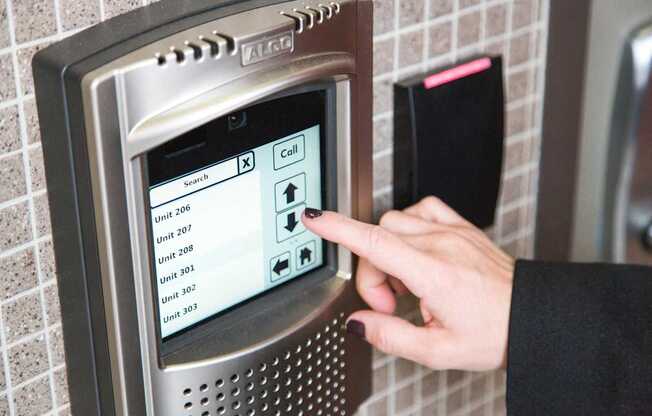 a hand pressing a button on a microwave oven