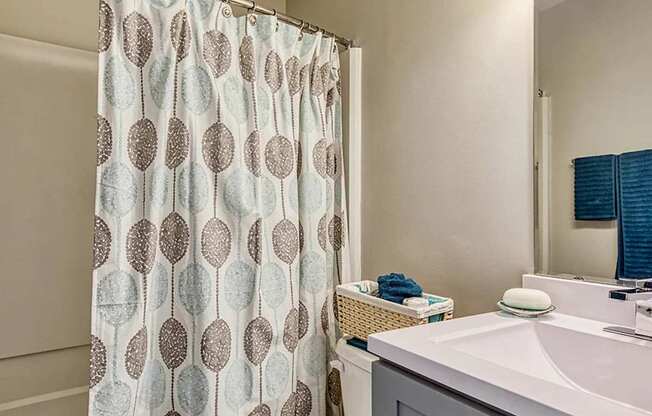 A shower curtain with a pattern of circles is hanging in a bathroom.