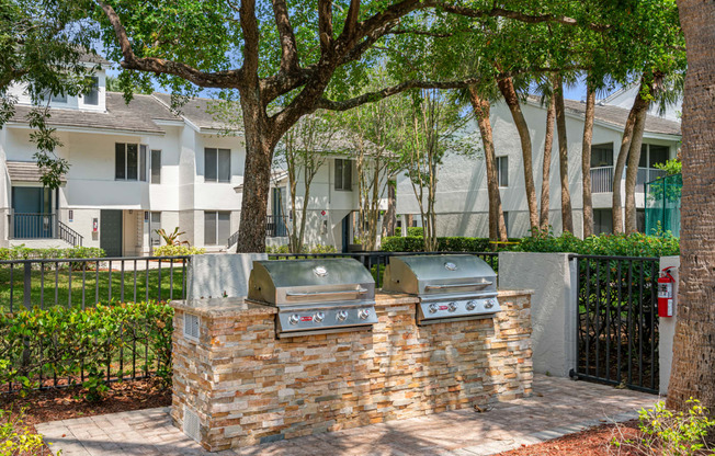 two stainless steel barbecue grills in front of an apartment building