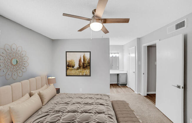 A bedroom with a large bed and a ceiling fan.