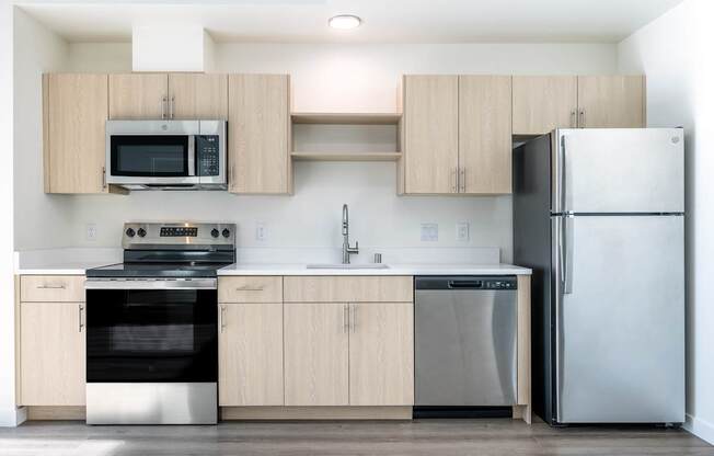 A kitchen with a white refrigerator, stove, oven, and microwave.