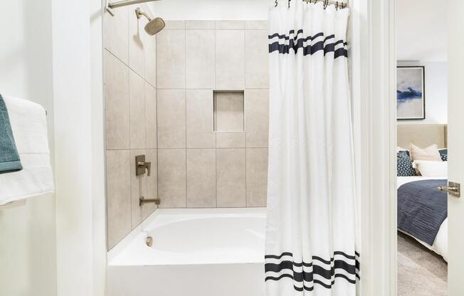 A clean-lined bath with a tiled tub surround and built-in niche, offering a comfortable setting for unwinding at the end of the day.