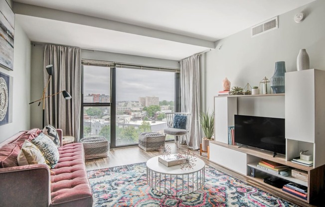 a living room with a couch and a tv and a window