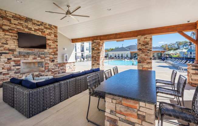 the clubhouse with a pool and a table with chairs and a tv