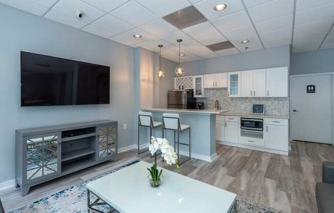 a kitchen and living room with a tv and a table