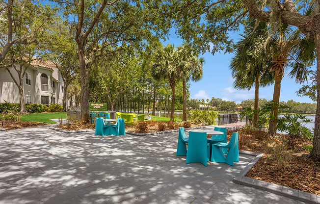 Patio with blue tables and chairs with the lake in the background